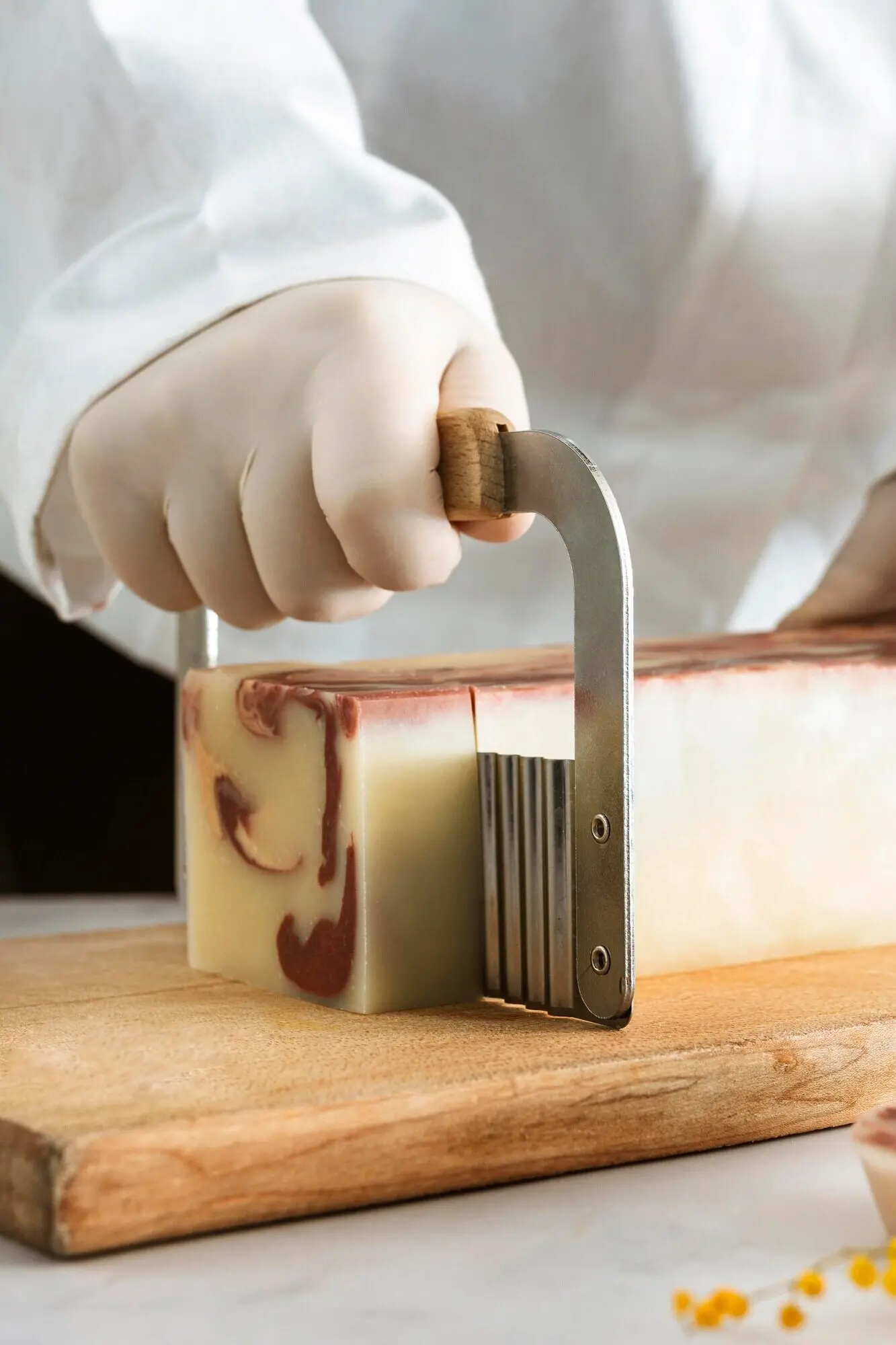 Nahaufnahme einer Hand, die Seife schneidet.