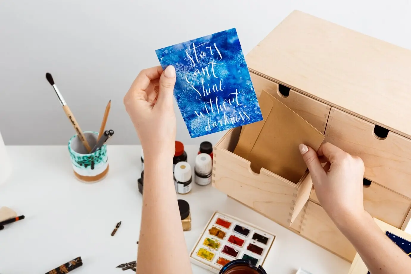 Die Hand eines Mädchens hält eine Postkarte mit der Aufschrift 